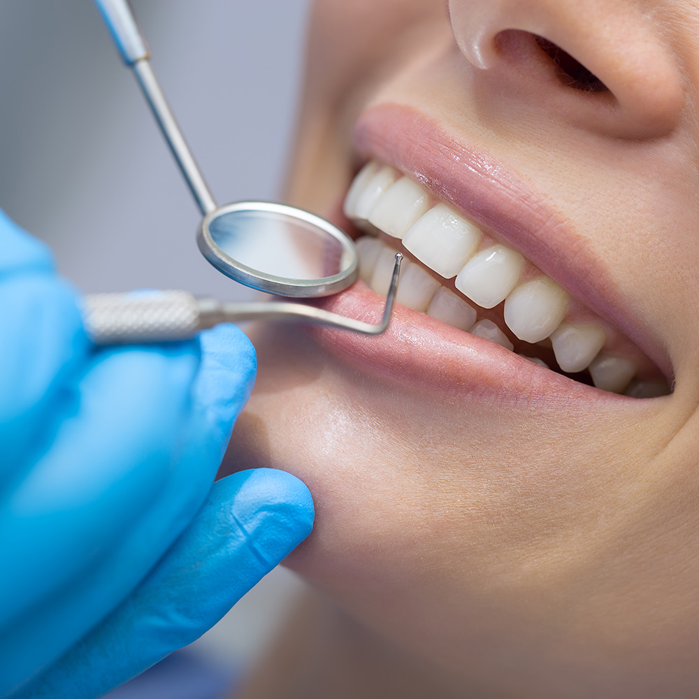Gute Zahnpflege ist jetzt wichtiger denn je. Eine Frau lässt ihre Zähne vom Zahnarzt kontrollieren.