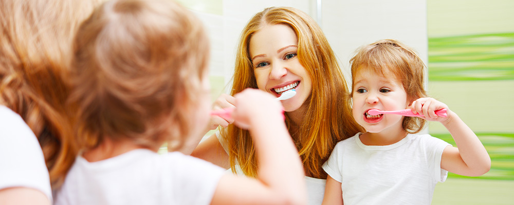 Der kranke Mund ist für Mutter und Kind kein Thema. Gemeinsam putzen sie sich vor dem Spiegel die Zähne.