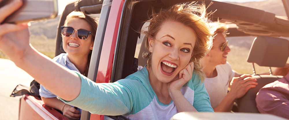 Gute Mundhygiene ist die Grundvoraussetzung für eine gesunde Mundflora. Eine Gruppe junger Menschen im Auto versprüht gute Laune.
